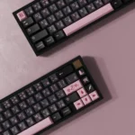 Close-up of premium Night Sakura R2 double-shot ABS keycaps, showcasing elegant deep hues and delicate pink cherry blossom accents from multiple angles.