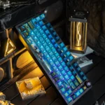 An exclusive Overwatch Pharah PBT keycap, revealing its unique side-engraved art and metallic paint finishes from a premium, detailed perspective.