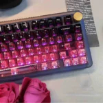 Angled view of premium black-pink PC gradient keycaps, highlighting their high-transparency and sleek design for vibrant RGB keyboards.