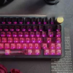 Angled view of black-pink PC gradient keycaps, showcasing high-transparency and stunning translucent design, perfect for a modern RGB keyboard.