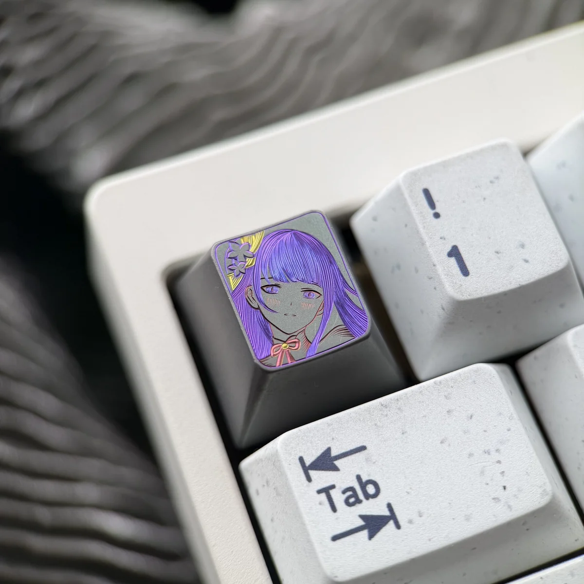 Artistic close-up of the hand-carved Raiden Shogun titanium artisan keycap, revealing its intricate design, matte finish, and powerful elegance.