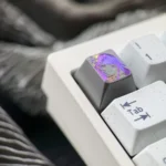 Multiple views of the hand-carved Raiden Shogun titanium artisan keycap, highlighting its intricate matte finish and elegant character lines from variant angles.