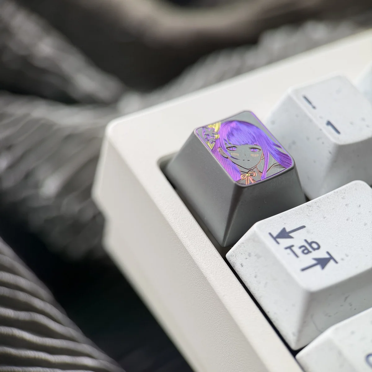 Multiple views of the hand-carved Raiden Shogun titanium artisan keycap, highlighting its intricate matte finish and elegant character lines from variant angles.