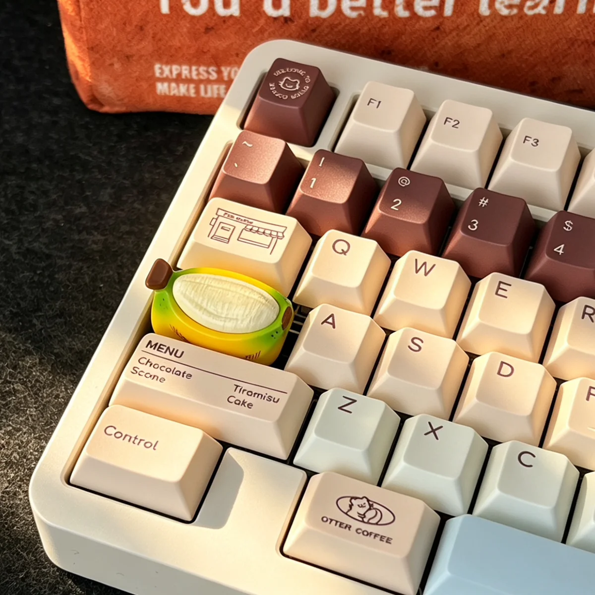Unique chubby banana hand-painted resin artisan keycap from various angles, showcasing handcrafted detail, vibrant color, and whimsical charm.