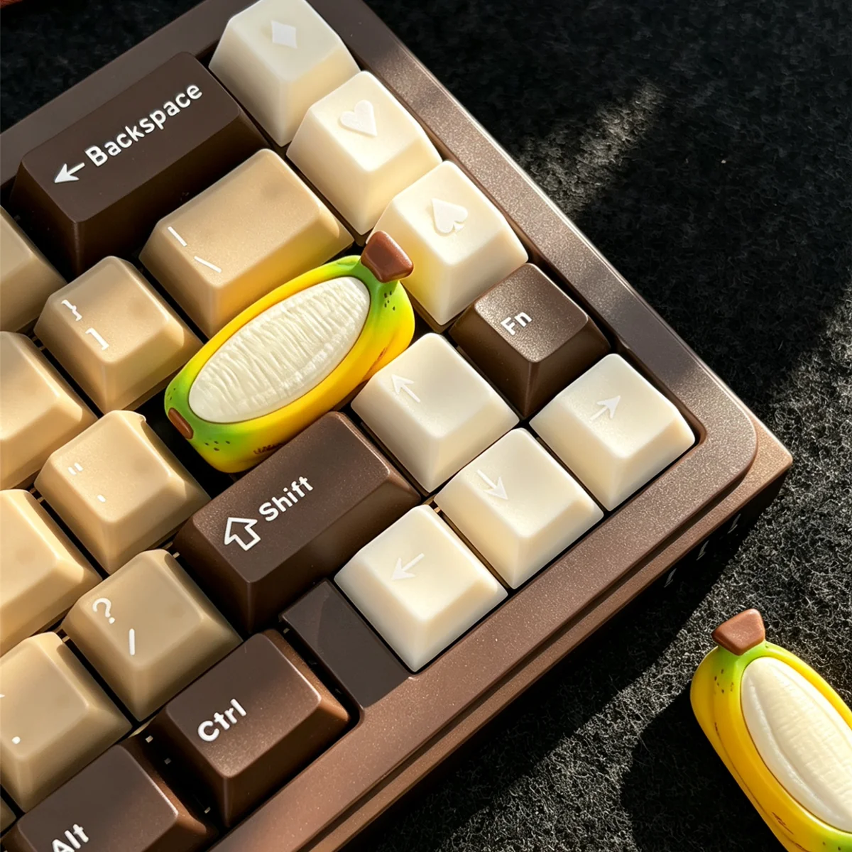 A cheerful chubby banana hand-painted resin artisan keycap, highlighting its unique handcrafted design and vibrant colors for a whimsical keyboard accent.
