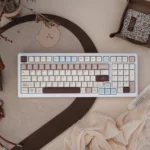 Joyful Cocoa Duck themed mechanical keyboard shown from various angles, highlighting its charming design, tri-mode connectivity, and silent linear switches.
