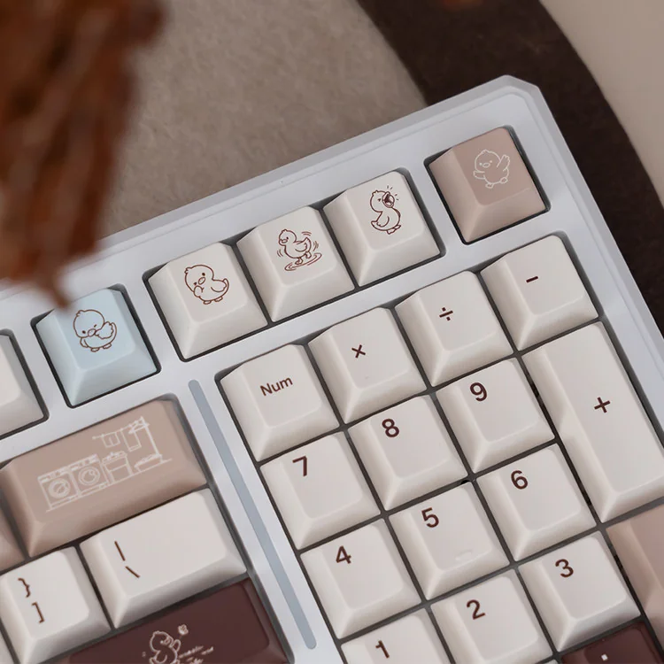 A delightful angle of the Joyful Cocoa Duck themed mechanical keyboard, showcasing its warm hues, tri-mode connectivity, and silent linear switches.