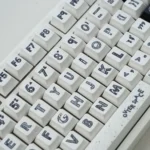 The 131-key Astronaut PBT Keycaps dye-sub set from various angles, with durable PBT and crisp, playful space legends on a clean white base.