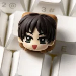 Hand-sculpted chibi Eren Attack on Titan keycap with a glossy resin finish on a white keyboard, playful anime design.