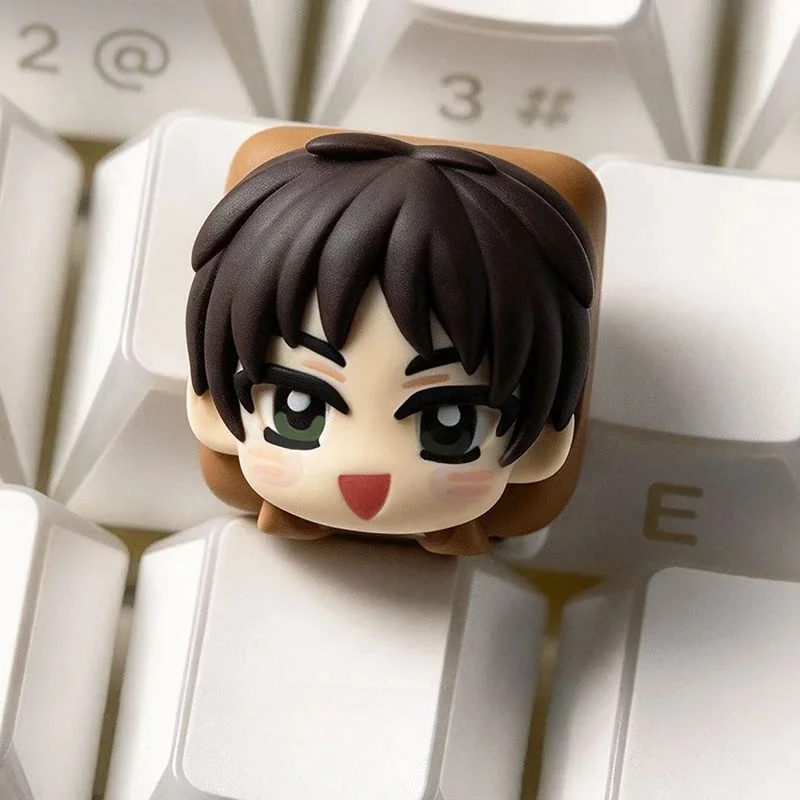 Hand-sculpted chibi Eren Attack on Titan keycap with a glossy resin finish on a white keyboard, playful anime design.