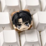 Hand-sculpted chibi Levi Attack on Titan keycap with glossy resin finish on a white keyboard, showing a playful anime character head.