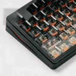 Close-up of glossy black gradient keycaps with side-lit legends, showing the Ink Frost fade from black to clear PC on a keyboard.