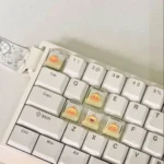 A close-up of the charming, handcrafted translucent Capybara Couple Lulu XDA keycaps, showing their playful details from multiple angles, illuminating a custom keyboard.