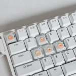 A playful, close-up view of the translucent Capybara Couple Lumei XDA keycaps, highlighting their whimsical illustration and ergonomic profile glowing from multiple angles.