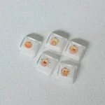 A playful gallery view of adorable translucent Capybara Couple Lumei XDA accent keycaps, showcasing their glowing PC material and whimsical design from variant angle.