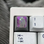 Close-up view of the artisan hand-carved Chainsaw Man Reze titanium keycap, revealing its dynamic design and vibrant details from a side perspective.
