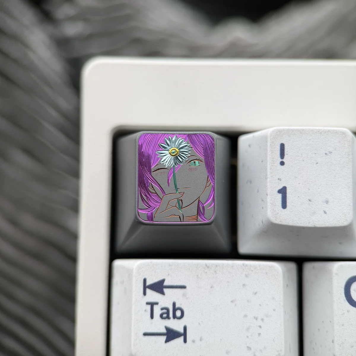 Close-up view of the artisan hand-carved Chainsaw Man Reze titanium keycap, revealing its dynamic design and vibrant details from a side perspective.