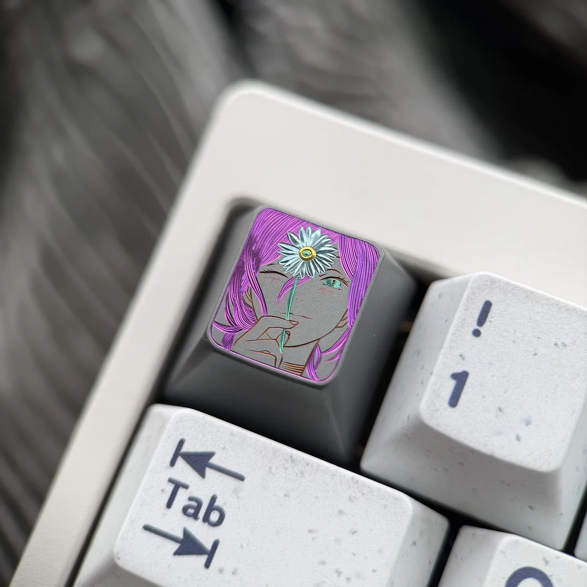 Artistic close-up of the hand-carved Chainsaw Man Reze titanium keycap from a unique angle, highlighting intricate details and vibrant accents.