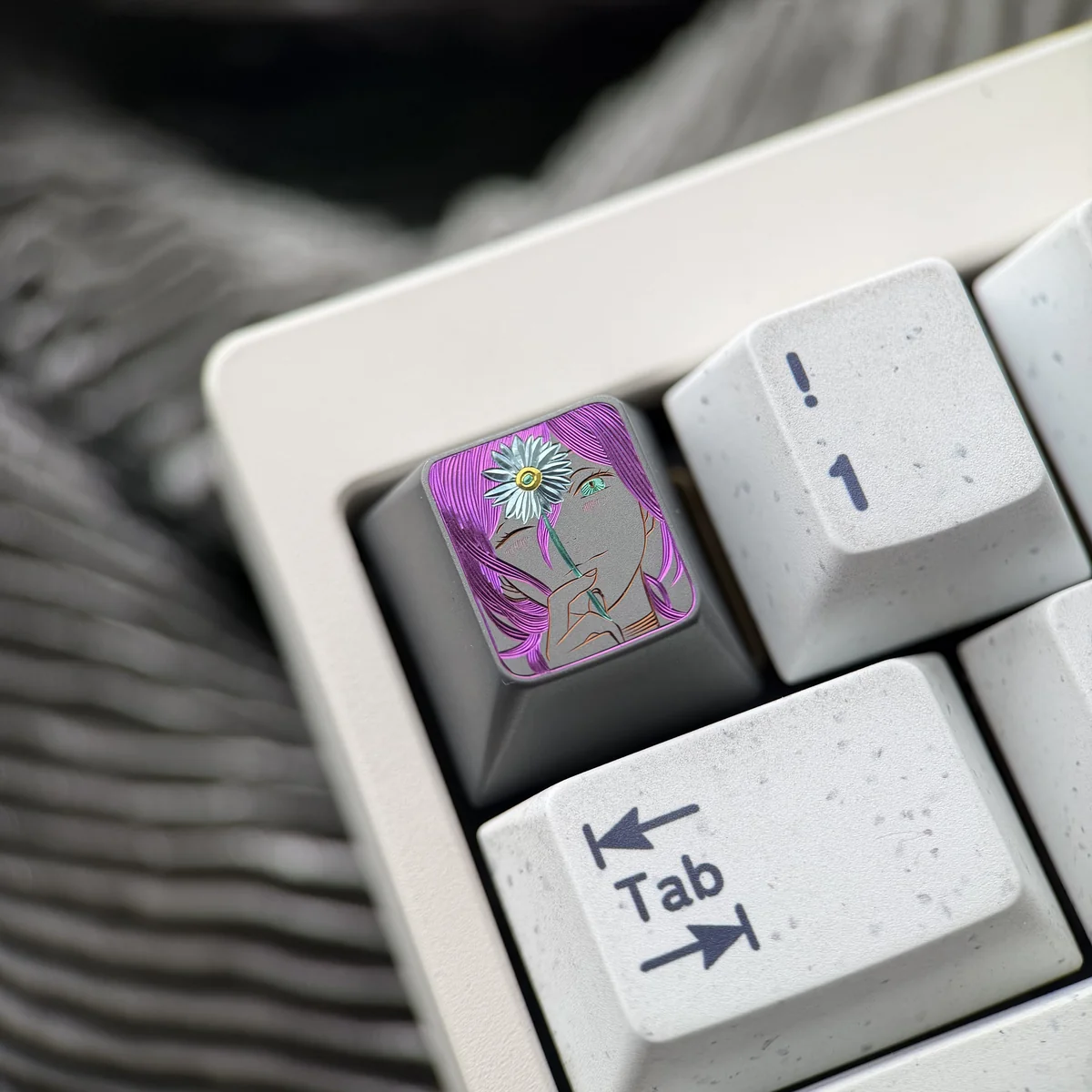 Close-up of the artisan hand-carved titanium Chainsaw Man Reze keycap, revealing its dynamic anime character design with vibrant metallic accents.