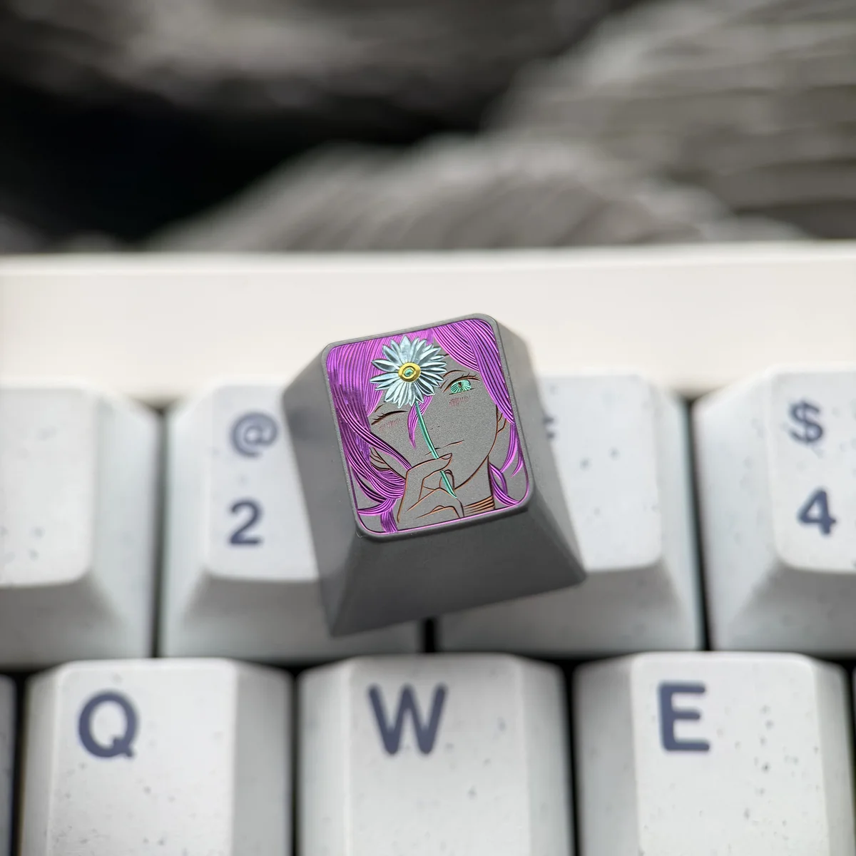 Artistic close-up of the hand-carved Titanium Chainsaw Man Reze keycap, highlighting its dynamic character details and metallic sheen from a distinct.