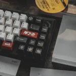 Close-up of Drift keycap set with white alphas, black modifiers, and red JDM car novelty keys in ABS double-shot on a mechanical keyboard.