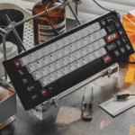 Drift keycap set with JDM ABS double-shot construction, featuring white alphas, black modifiers, and red car novelties in an artistic racing setup.