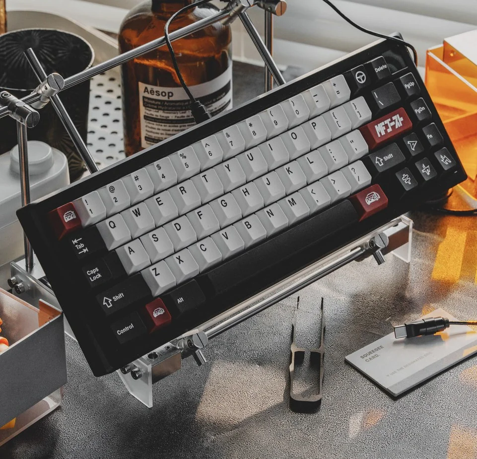 Drift keycap set with JDM ABS double-shot construction, featuring white alphas, black modifiers, and red car novelties in an artistic racing setup.