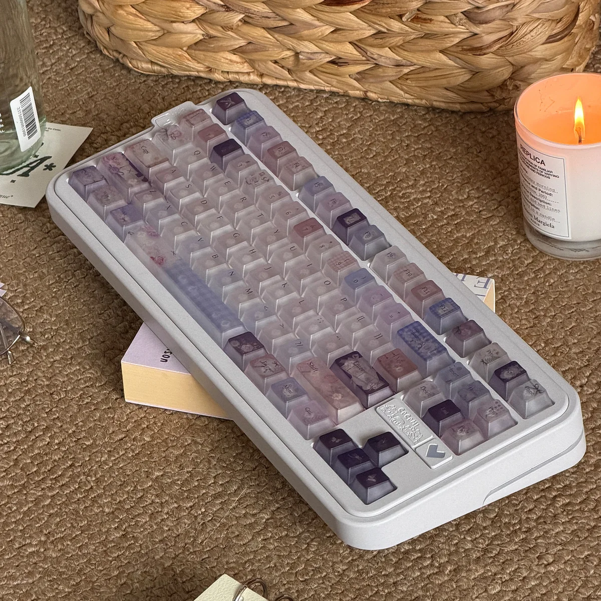 Frosted floral keycaps in pastel purple and pink add a dreamy floral touch to this white mechanical keyboard in soft light.
