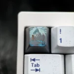 Hand-carved titanium Gojo Satoru keycap with a monochrome portrait and vivid blue accents on dark metal, shown on a keyboard.