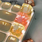 Handcrafted 3D camellia artisan resin keycap, SA Profile, showcasing delicate blooms, clear resin, and shimmering metallic foil from an artistic angle.