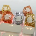 Close-up of a handcrafted 3D camellia artisan resin keycap, showcasing delicate blooms and shimmering foil encased in clear resin, perfect for SA profile.