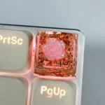 Handcrafted 3D pink camellia artisan resin keycap with delicate silver foil accents, SA profile, reflecting an artistic and unique design.