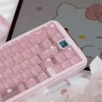 Frosted Pink Hello Kitty keycaps with glossy candy-like finish, showing cute motifs on a soft pink fog-transparent PC full keycap set.