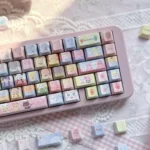 Pastel rainbow Jewelpet keycaps on a pink keyboard, featuring a 130-key PBT translucent set with animal characters and side-lit legends.