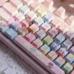 This angled close-up shows Jewelpet keycaps, a 130-key PBT pastel translucent set with rainbow animal characters, side-lit legends, and kawaii charm.