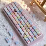 Pastel rainbow Jewelpet keycaps on a pink keyboard, a 130-key PBT translucent set with kawaii animal characters and side-lit legends.