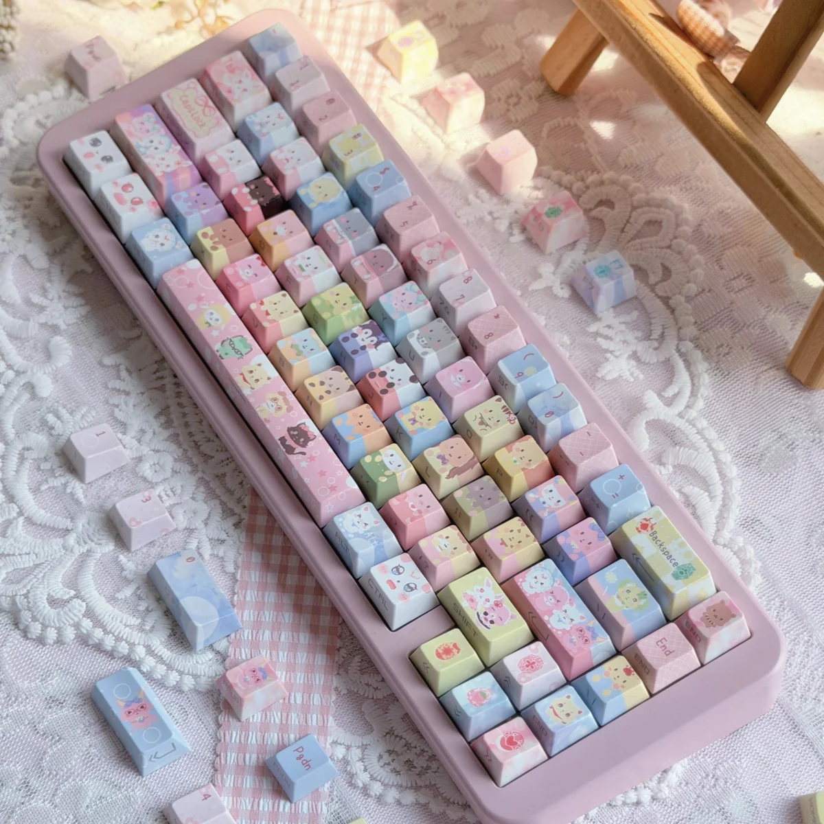 Pastel rainbow Jewelpet keycaps on a pink keyboard, a 130-key PBT translucent set with kawaii animal characters and side-lit legends.