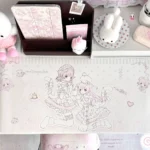 This pastel pink kawaii anime desk mat shows lolita cat-girl line art with ribbons, hearts and polka dots on oversized waterproof non-slip PU.