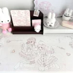 Pastel pink kawaii anime desk mat with lolita cat-girl line art, ribbons, hearts and polka dots on an oversized waterproof non-slip PU mat.