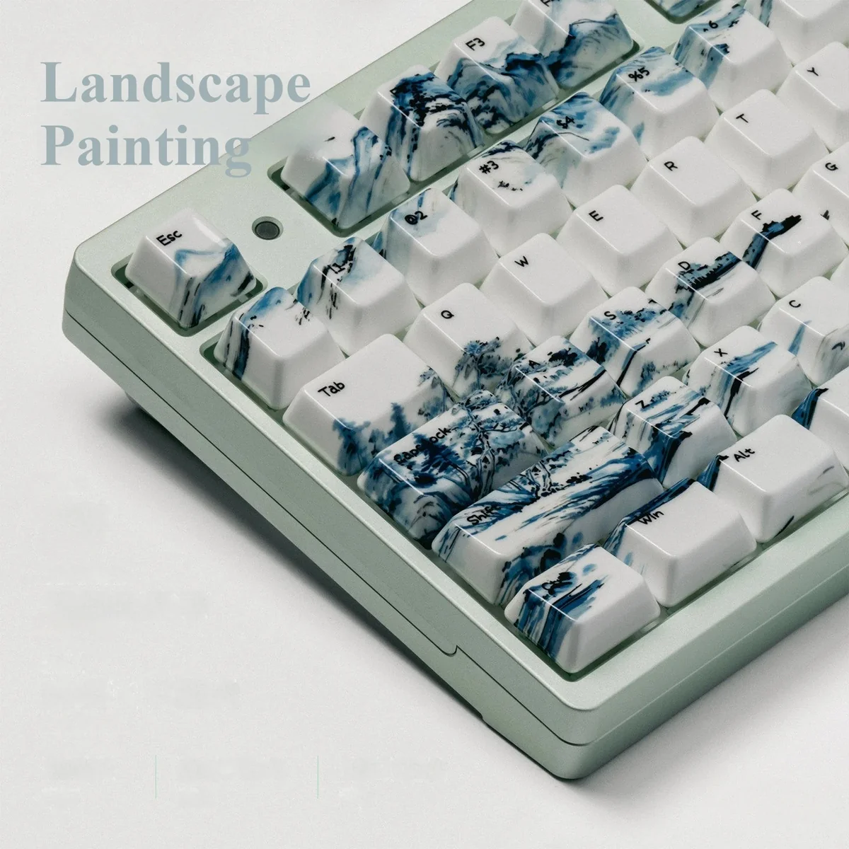 Landscape Painting ceramic keycap, angled view, traditional landscape art. Smooth, high-gloss artisan keycap for Zen desks.