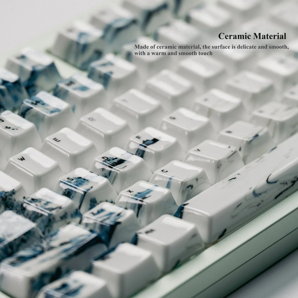 Landscape Painting ceramic keycap, angled view. Shows smooth, high-gloss finish and detailed traditional landscape art for Zen desks.