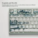 Landscape Painting ceramic artisan keycap, showing a serene traditional landscape painting on its smooth, high-gloss surface from an overhead view.
