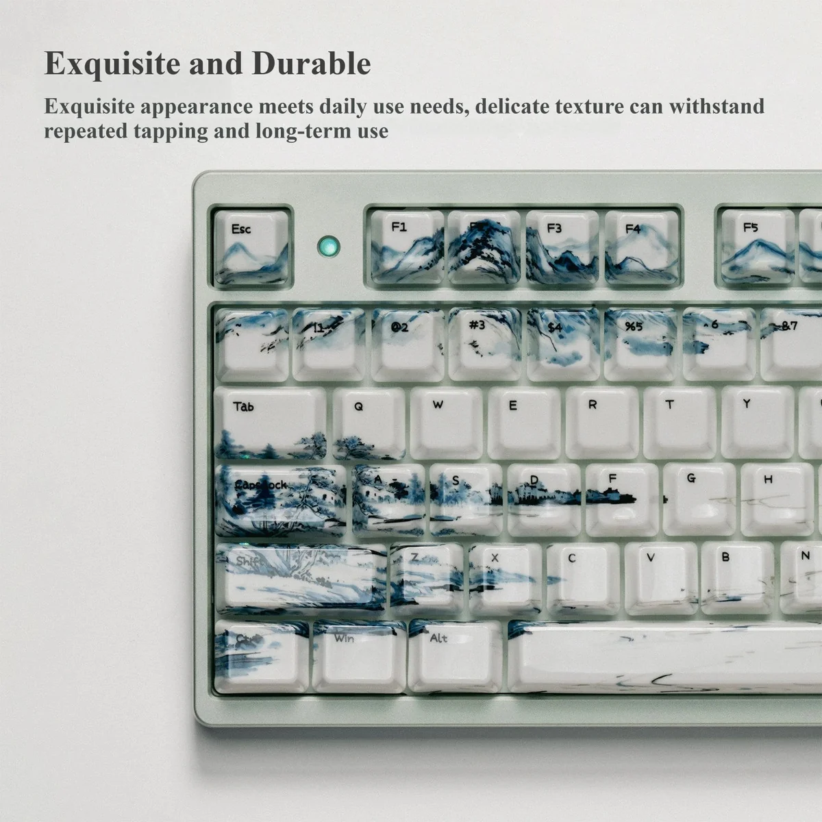 Landscape Painting ceramic artisan keycap, showing a serene traditional landscape painting on its smooth, high-gloss surface from an overhead view.