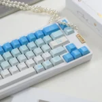 Close-up of durable PBT Leisure Rabbit keycaps in whimsical blue and white, featuring intricate rabbit designs across a serene.