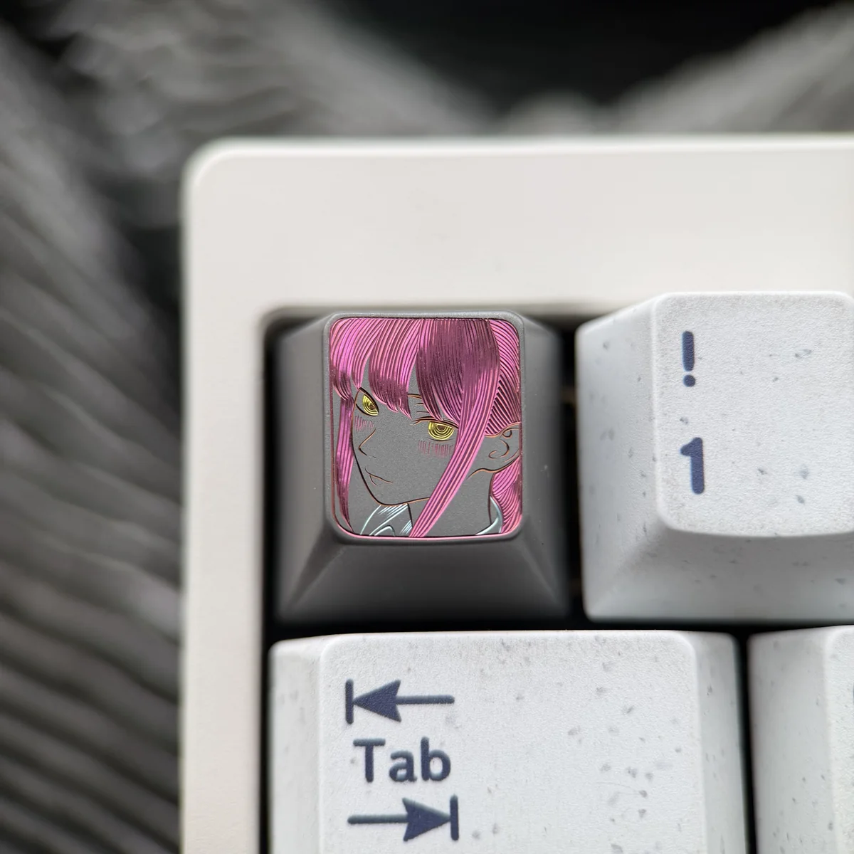 Hand-carved titanium Makima artisan keycap, showcasing intricate Chainsaw Man character details with a dark, artistic metallic finish on a keyboard.