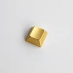 Close-up of a premium blank zinc alloy R1 directional metal keycap, showcasing its sleek, unadorned industrial-chic finish from various angles.