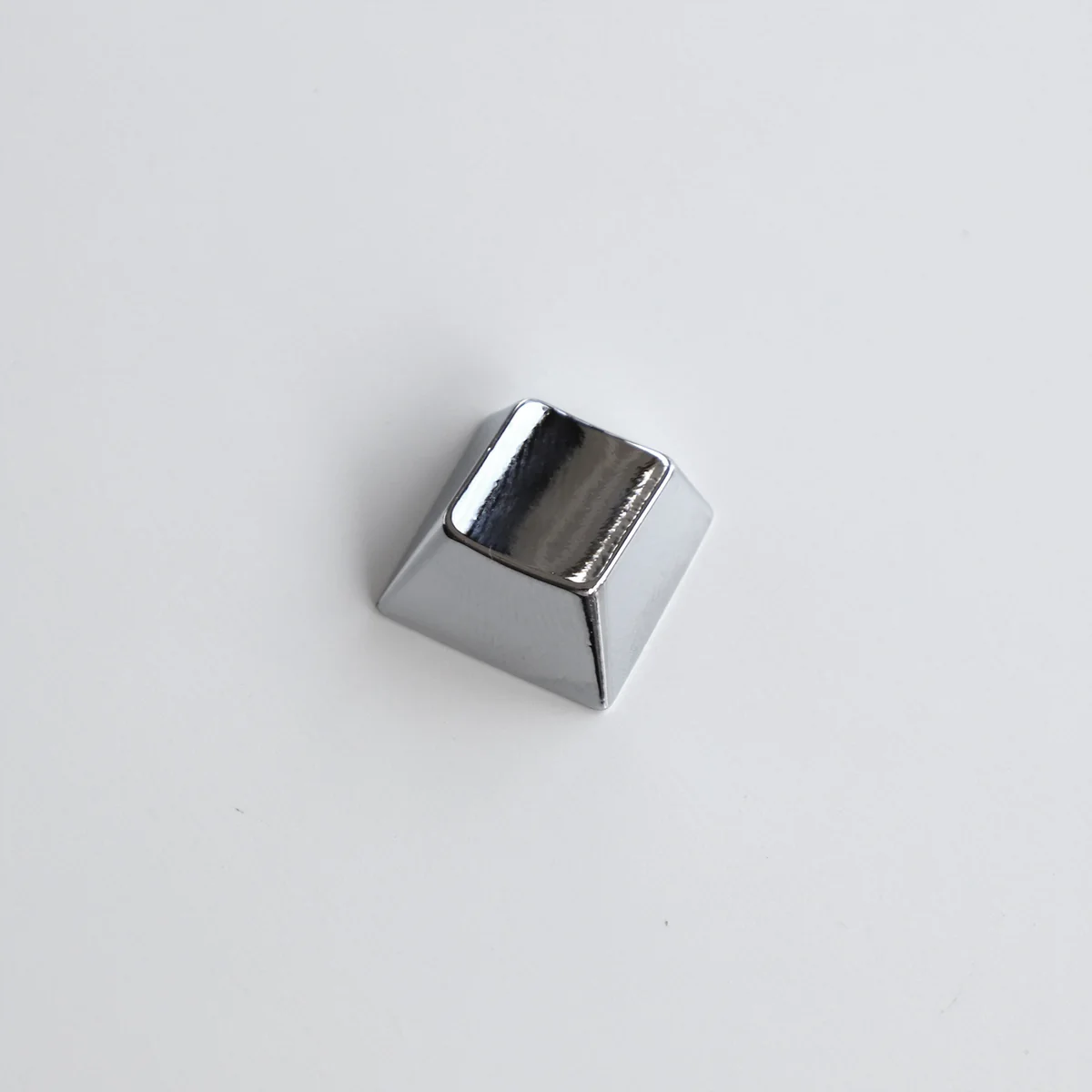 Close-up gallery of a premium blank zinc alloy R1 directional metal keycap, showcasing its sleek, modern industrial-chic finish from multiple angles。