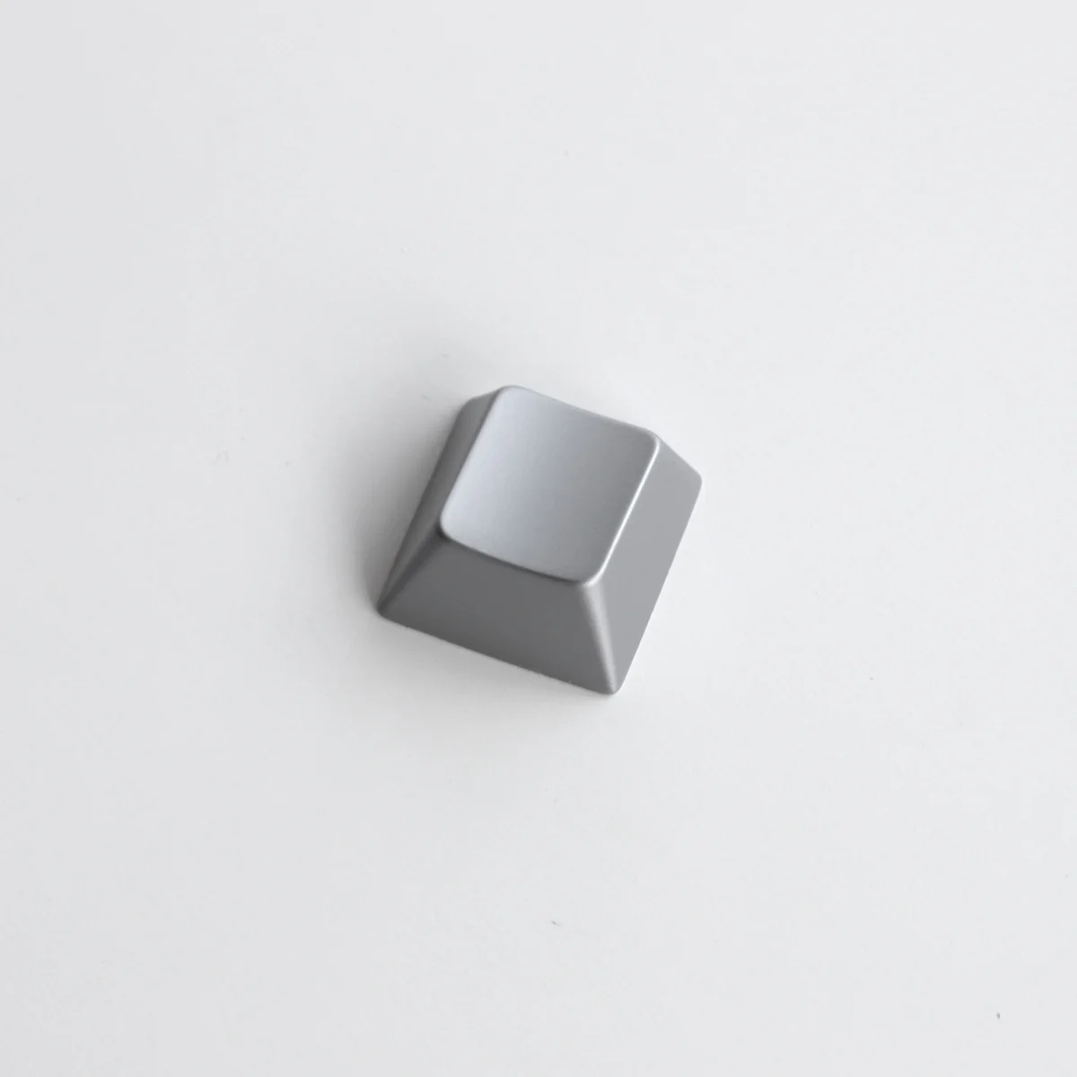 Gallery of premium blank zinc alloy R1 directional metal keycaps, highlighting their sleek, modern industrial-chic design from multiple angles.