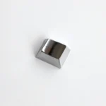 A collection of premium zinc alloy R1 1.25u blank metal keycaps displayed from various angles, showcasing their sleek metallic finish and minimalist design.
