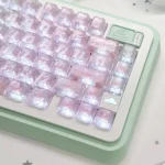 A unique mint carbon fiber transparent PC keycap for MX keyboards, showcasing its intricate carbon fiber pattern and cool translucent design from multiple angles.